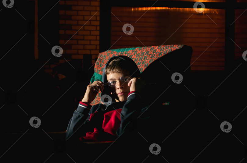 Скачать Маленький мальчик сидит в кресле во дворе дома фотосток Ozero
