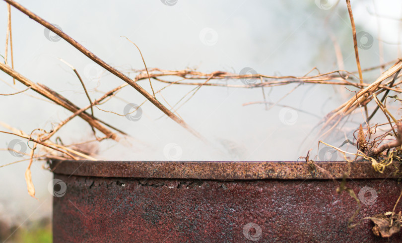 Скачать Горящий хворост и листья в старой ржавой бочке фотосток Ozero