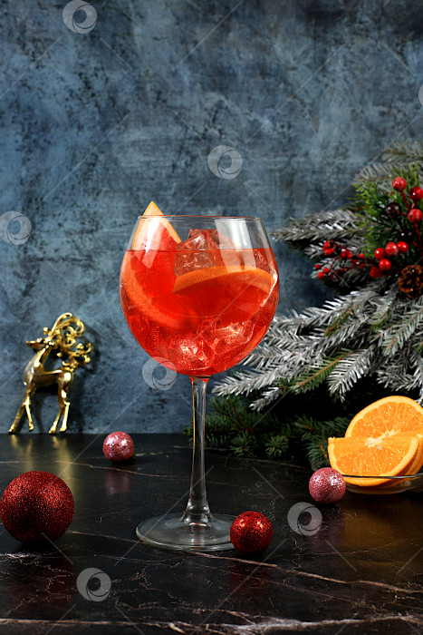 Скачать Рождественский алкогольный коктейль Aperol spritz в бокалах на праздничном фоне с еловыми ветками и украшениями, концепция бара и канун нового года, алкогольные напитки на вечеринке, фотосток Ozero