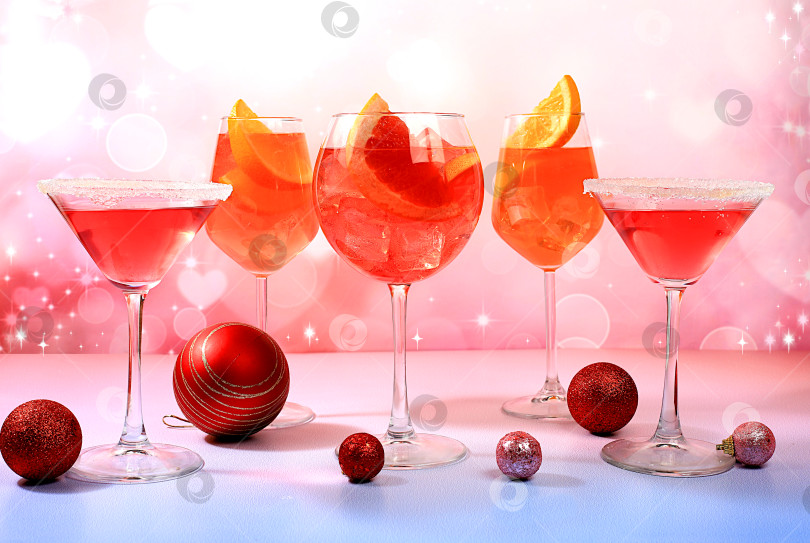Скачать Рождественский алкогольный коктейль Aperol spritz и красный мартини в бокалах на праздничном фоне с еловыми ветками и украшениями, концепция бара и канун нового года, алкогольные напитки на вечеринке, фотосток Ozero