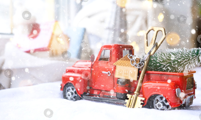 Скачать Красный ретро-автомобиль с рождественской елкой украшает ключ от дома в пикапе на Рождество. Покупка дома, переезд, ипотека, кредит, недвижимость, праздничное настроение, Новый год фотосток Ozero