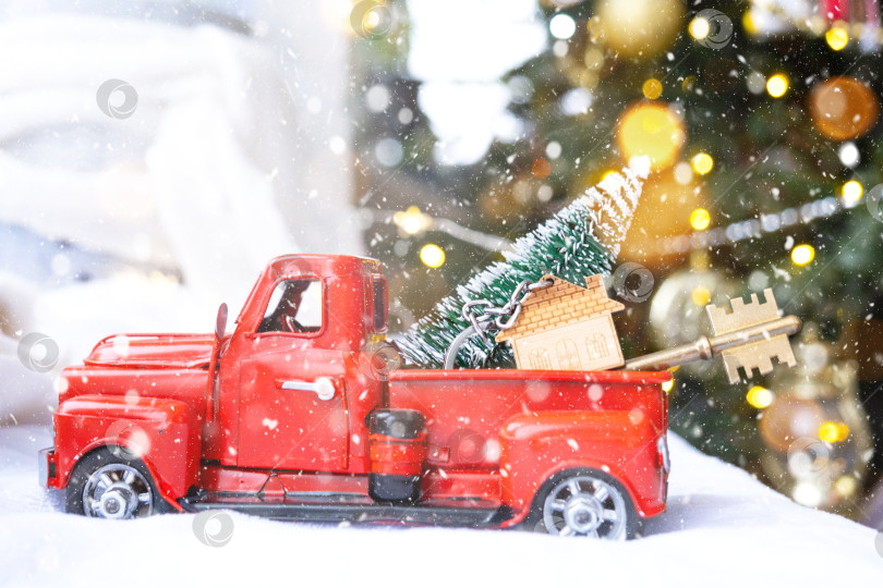 Скачать Красный ретро-автомобиль с рождественской елкой украшает ключ от дома в пикапе на Рождество. Покупка дома, переезд, ипотека, кредит, недвижимость, праздничное настроение, Новый год фотосток Ozero