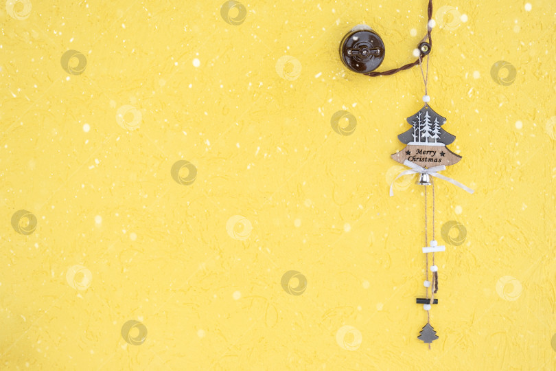 Скачать Подвеска в форме рождественской елки с надписью "Счастливого Рождества" висит на входной двери дома на колокольчике с ретро-проводкой со снегом. Пространство для копирования фотосток Ozero