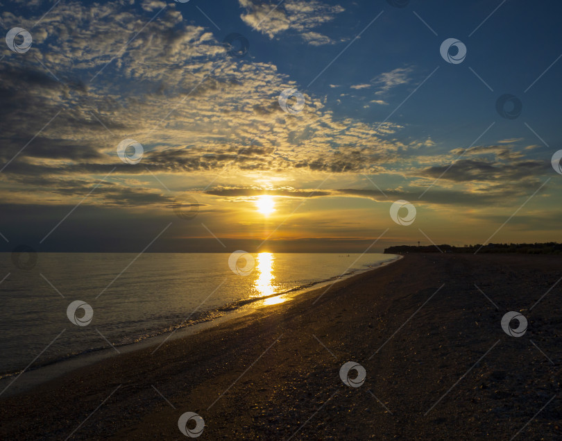Скачать Красивый закат на море, вид с пляжа. Голубое небо с радужными облаками. Песчаный пляж и спокойное море фотосток Ozero