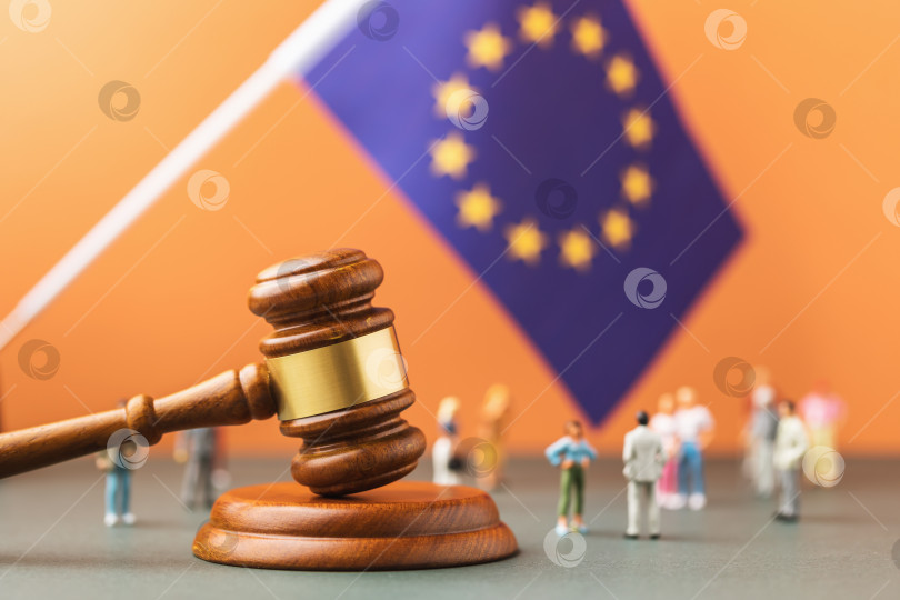 Скачать Судейский молоток, флаг Европейского Союза и пластмассовые игрушечные человечки на цветном фоне - концепция судебного разбирательства в европейском обществе фотосток Ozero