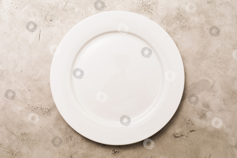 Скачать Пустая белая керамическая тарелка на светлом абстрактном фоне, вид сверху, фон для еды фотосток Ozero