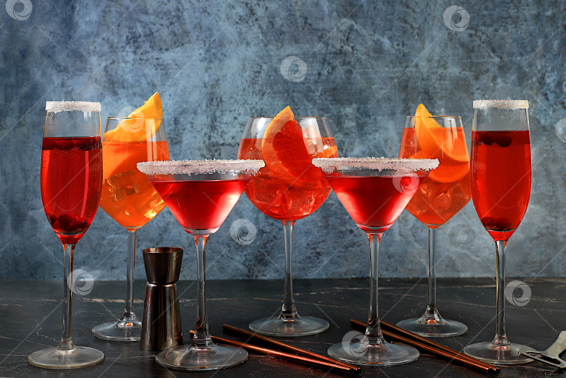 Скачать Ассортимент алкогольных коктейлей Aperol spritz, шампанского и красного мартини в бокалах на темном фоне, концепция бара, алкогольные напитки на вечеринке, реклама ресторана, фотосток Ozero