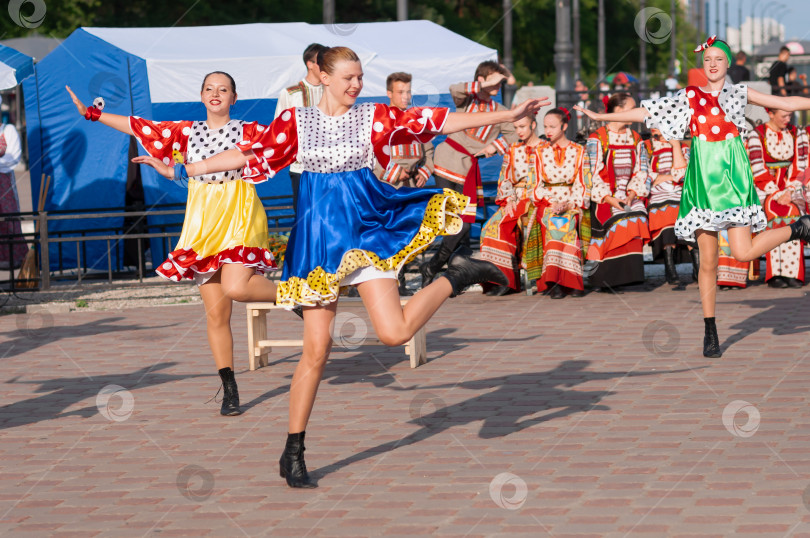 Скачать БЛАГОВЕЩЕНСК, РОССИЯ - 15 июля 2023 года: Выступление творческой группы в русских народных костюмах на набережной. Девушки танцуют динамичный танец фотосток Ozero