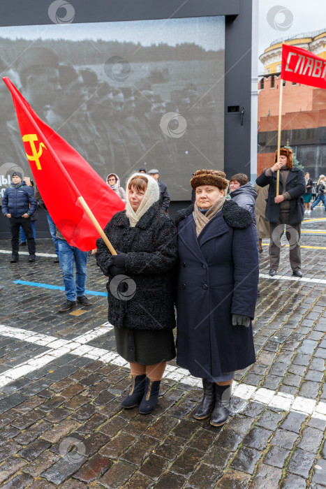 Скачать Москва, Россия - Ноябрь 07,2023: Женщины с красным знаменем в одежде 40-х годов прошлого века фотосток Ozero