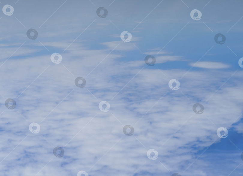 Скачать Вид сверху на белые пушистые перистые облака на фоне голубого неба. Абстрактный фон неба. Малая глубина резкости фотосток Ozero