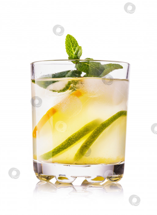 Скачать Вода с лимоном и лаймом в прозрачном бокале с кусочками фруктов, выделенными на белом фоне фотосток Ozero