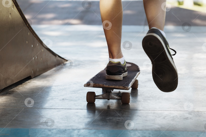 Скачать Ноги мужчины, катающегося на скейтборде в парке, крупным планом фотосток Ozero