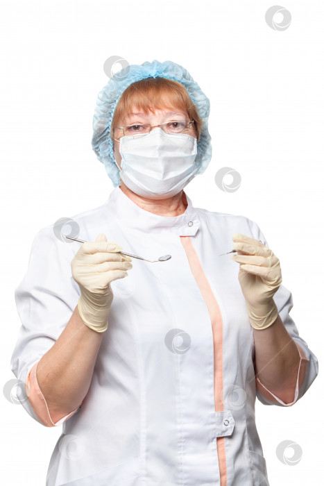 Скачать женщина-стоматолог в маске держит инструменты, готовые к работе, изолированные на белом фоне фотосток Ozero