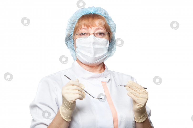 Скачать женщина-стоматолог в маске держит инструменты, готовые к работе, изолированные на белом фоне фотосток Ozero
