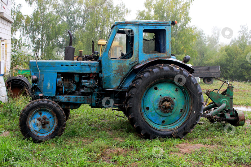 Скачать Фотография старого синего трактора на деревьях. фотосток Ozero
