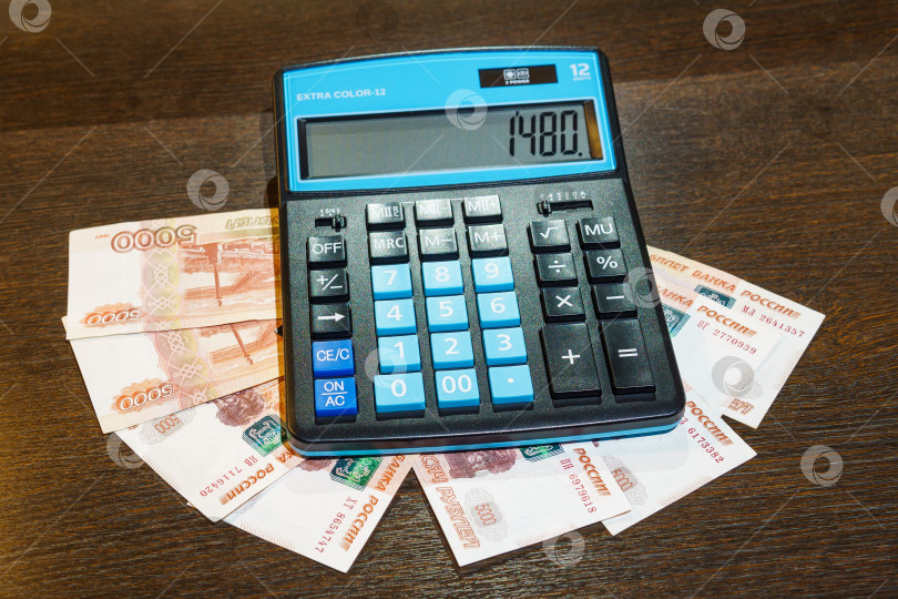 Скачать Калькулятор лежит на купюрах по пять тысяч рублей фотосток Ozero