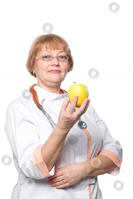 Скачать женщина-врач улыбается со стетоскопом, держа в руке свежее яблоко дрина. Изолированный на белом фоне фотосток Ozero
