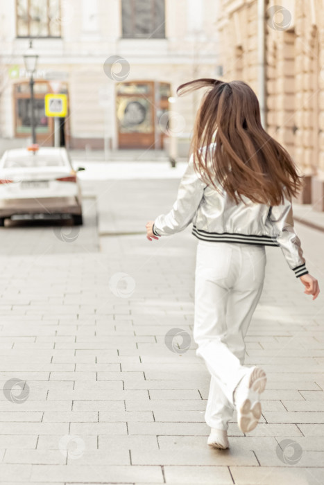Скачать Счастливая жизнерадостная девушка бегает и танцует по улице. фотосток Ozero