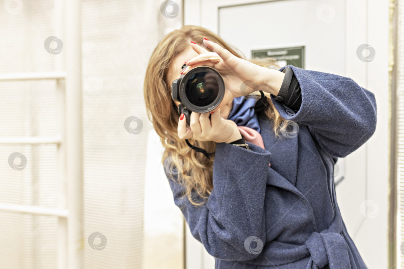 Скачать Женщина-фотограф с фотоаппаратом в руках делает снимок. Папарацци с фотоаппаратом в руках на природе, в городе фотосток Ozero