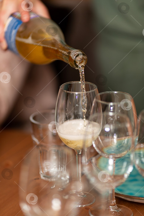 Скачать Сомелье наливает белое игристое вино в бокал фотосток Ozero