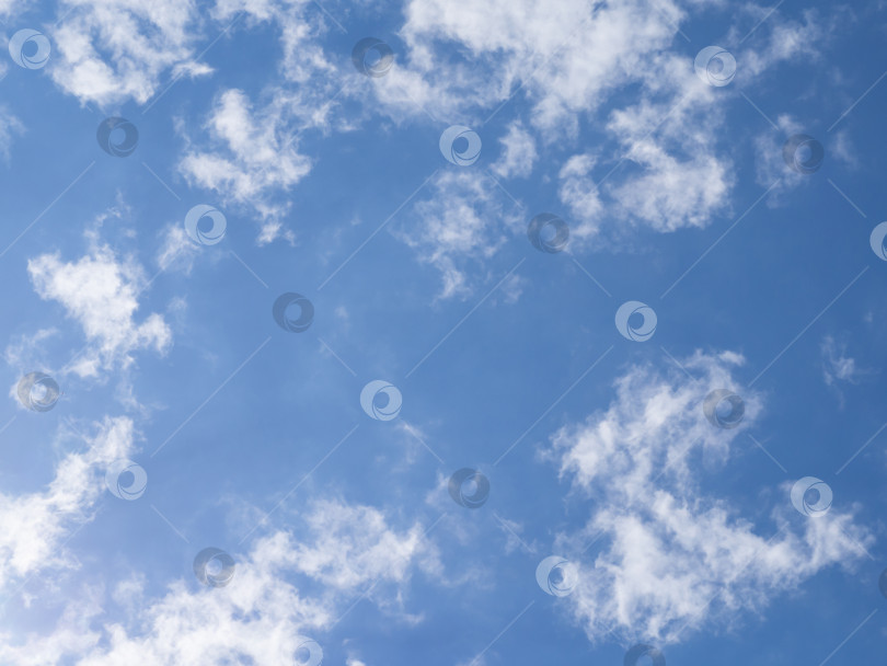 Скачать Голубое небо и легкие белые облака, освещенные светом в солнечный день. Удивительный фон неба для дизайна или обоев фотосток Ozero