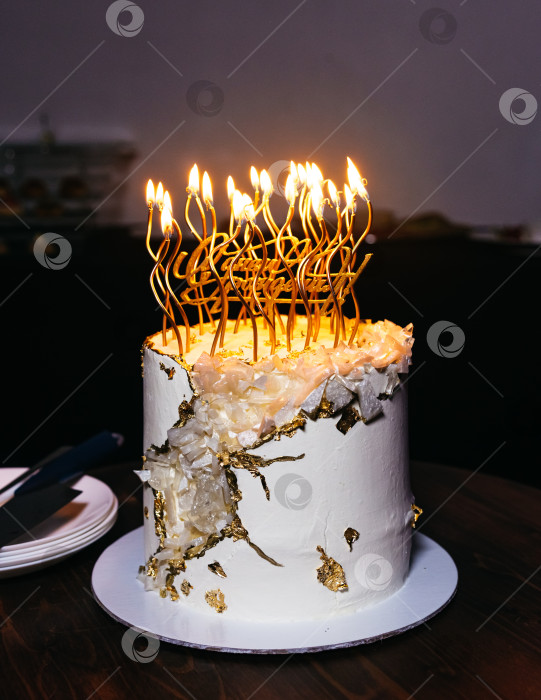 Скачать Белый торт, украшенный множеством зажженных свечей фотосток Ozero