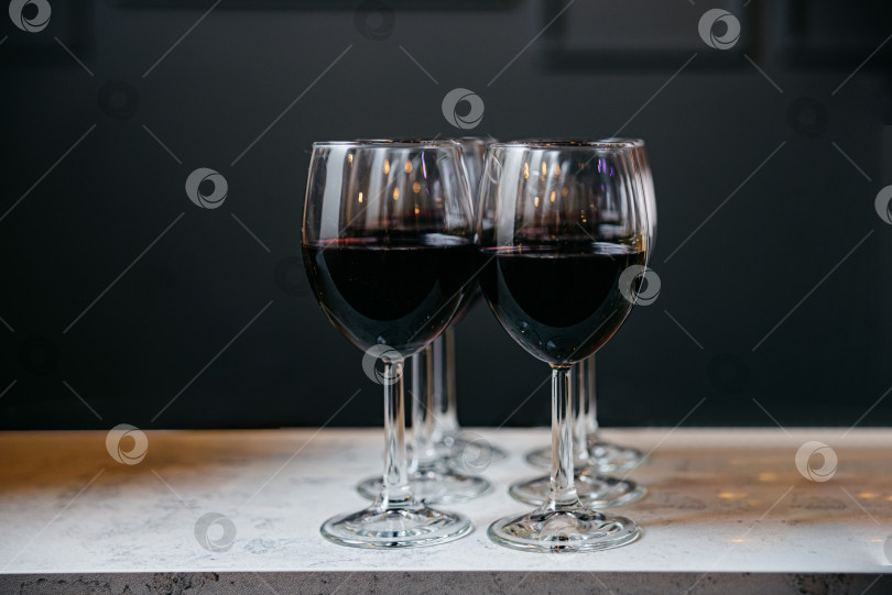 Скачать Тост за вечер: Два бокала красного вина на столе фотосток Ozero