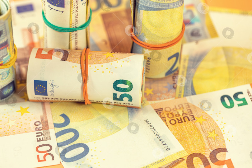 Скачать Фон из скрученных и разбросанных банкнот евро фотосток Ozero