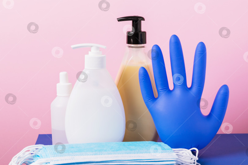 Скачать Дезинфицирующие средства, мыло, одноразовые медицинские маски и перчатки на розовом фоне фотосток Ozero