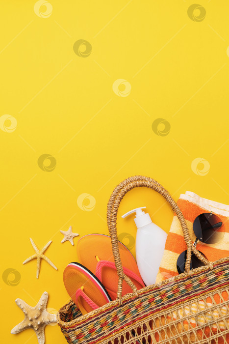 Скачать Пляжная сумка с аксессуарами для отдыха на желтом фоне и копировальным пространством, летний фон фотосток Ozero