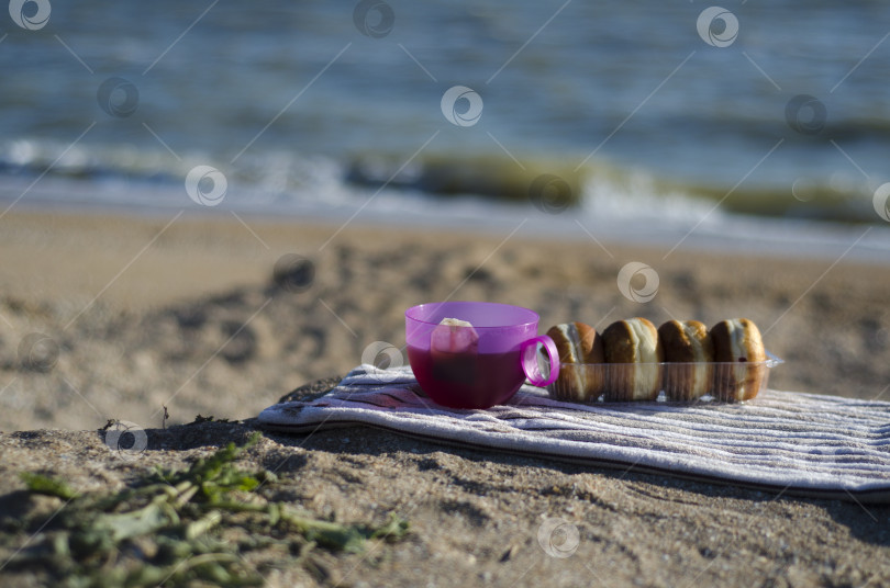 Скачать Завтрак на берегу моря. Чай и свежие пончики на берегу Азовского моря фотосток Ozero