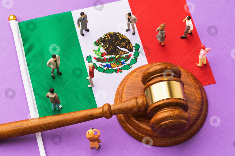 Скачать Судейский молоток, флаг Мексики и пластмассовые игрушечные человечки на цветном фоне, концепция судебного разбирательства в мексиканском обществе фотосток Ozero