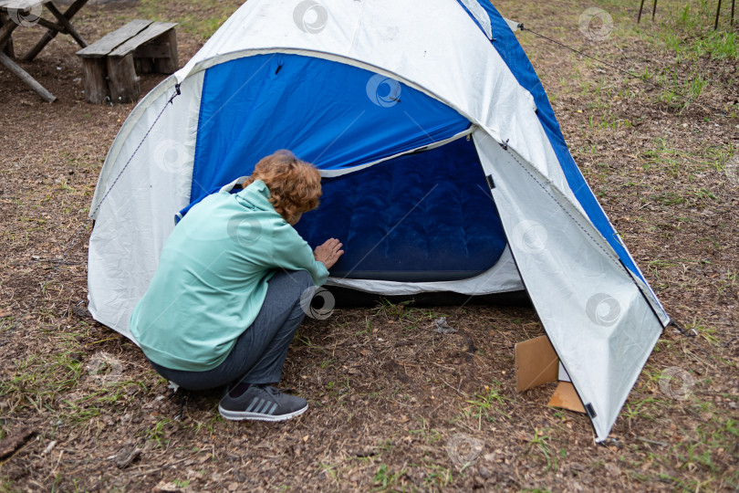 Скачать Женщина ставит палатку в лесу. Путешествия. фотосток Ozero