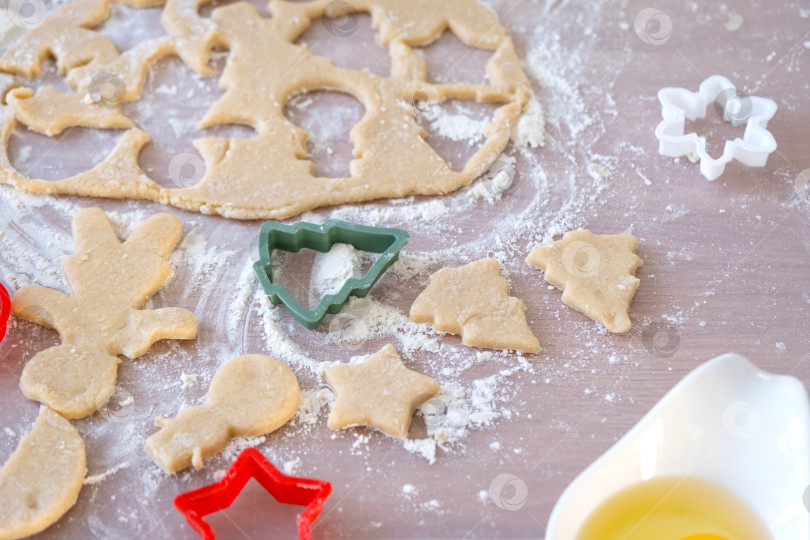 Скачать Макет формочек для печенья крупным планом вырезаем печенье из теста формочками на рождественскую тематику в виде снеговика, рождественской елки, звезд на кухне фотосток Ozero