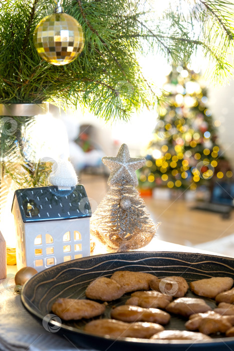 Скачать Праздничный рождественский декор на столе, домашняя выпечка на завтрак, печенье из пекарни. Уютный дом, рождественская елка с гирляндами сказочных огней. Новогоднее, рождественское настроение фотосток Ozero