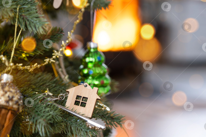 Скачать Ключ от дома с брелком висит на елке. Подарок на Новый год, Рождество. Строительство, дизайн, проект, переезд в новый дом, ипотека, аренда и покупка недвижимости. Место для копирования фотосток Ozero