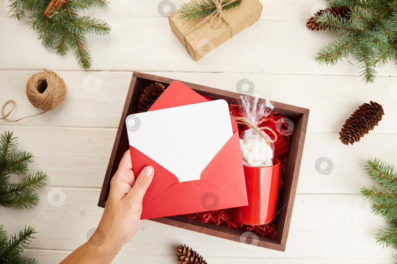 Скачать Коробка с подарками на Рождество и Новый год: красная кружка с зефиром, экологически чистые украшения фотосток Ozero
