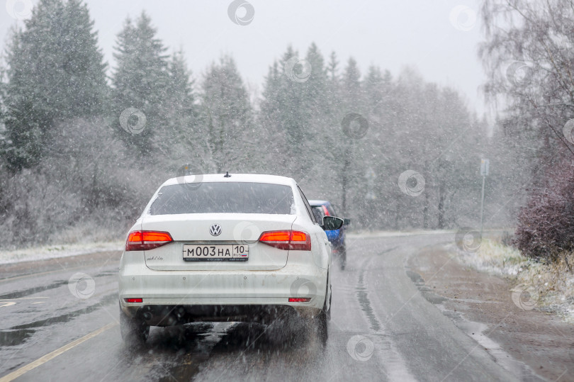Скачать Россия, Санкт-Петербург, ноябрь 2023 года: автомобиль едет по скользкой заснеженной дороге в начале первых заморозков фотосток Ozero