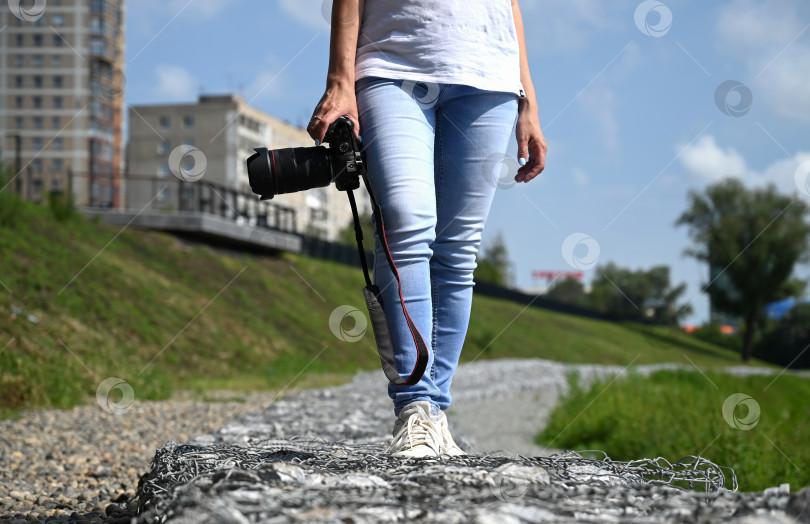 Скачать женщина-фотограф с фотоаппаратом в руках прогуливается по улицам города фотосток Ozero