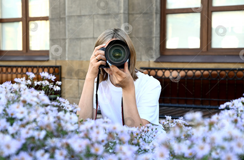 Скачать женщина-фотограф с фотоаппаратом в руках прогуливается по улицам города фотосток Ozero