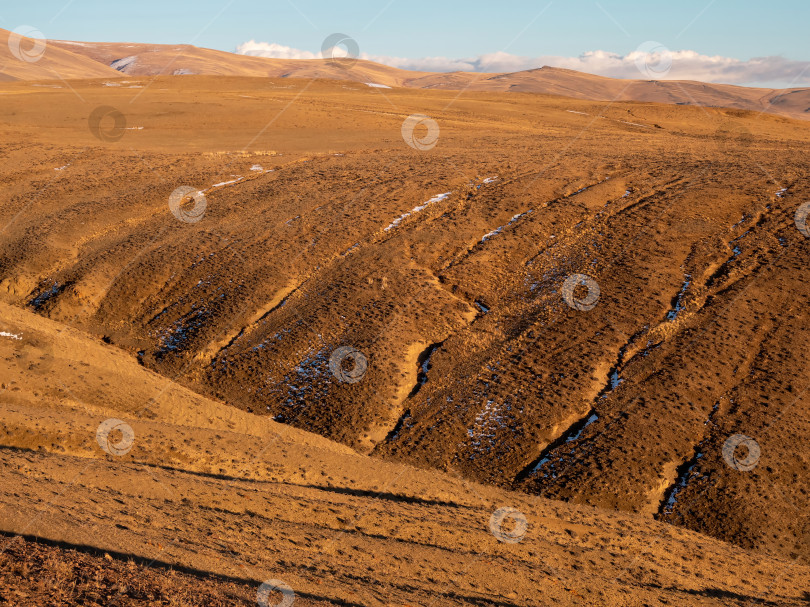 Скачать Необычная текстура гор, в прожилках скалы есть снег, поверхность плато нагрета солнцем. Удивительное красное горное плато на закате слегка припорошено снегом. фотосток Ozero
