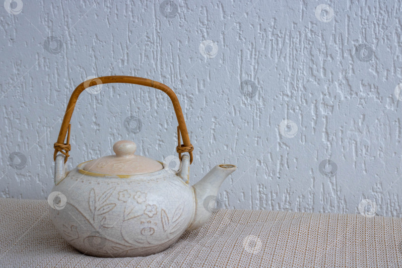 Скачать Старый чайник из светлой глины с трещинами и царапинами на белом фоне. фотосток Ozero