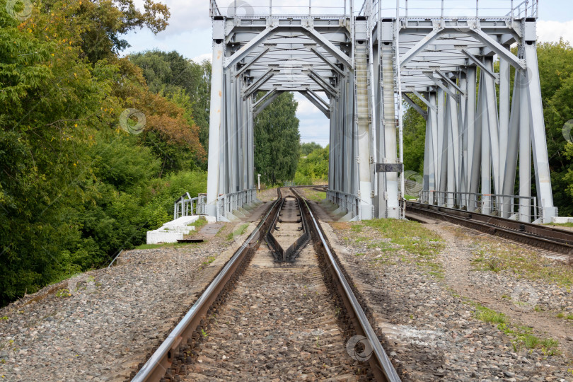 Скачать Железнодорожный путь на стальной мостовой конструкции в сельской местности фотосток Ozero