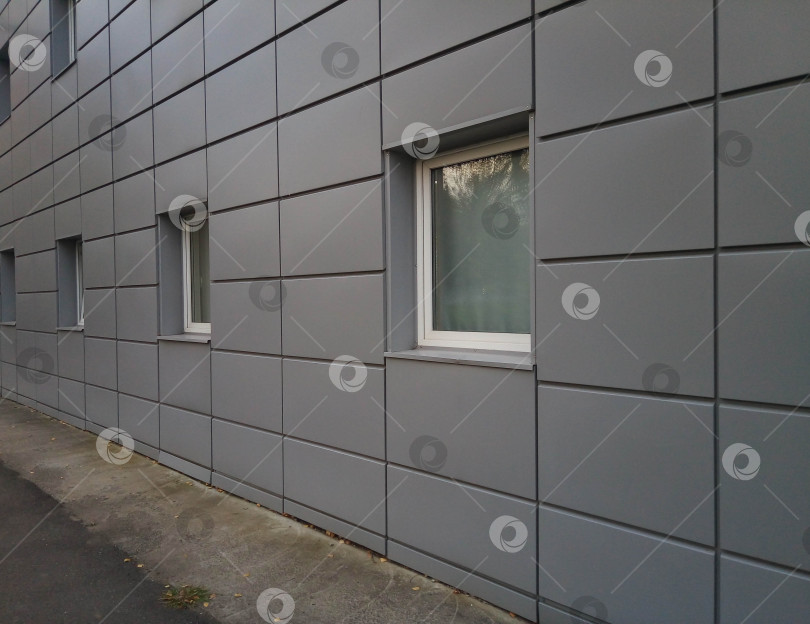 Скачать Серый фасад с маленькими квадратными белыми окнами фотосток Ozero