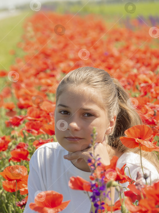 Скачать Портрет счастливой молодой девушки на поле с цветами мака. Девочка-подросток проводит свое свободное время на природе среди цветов фотосток Ozero