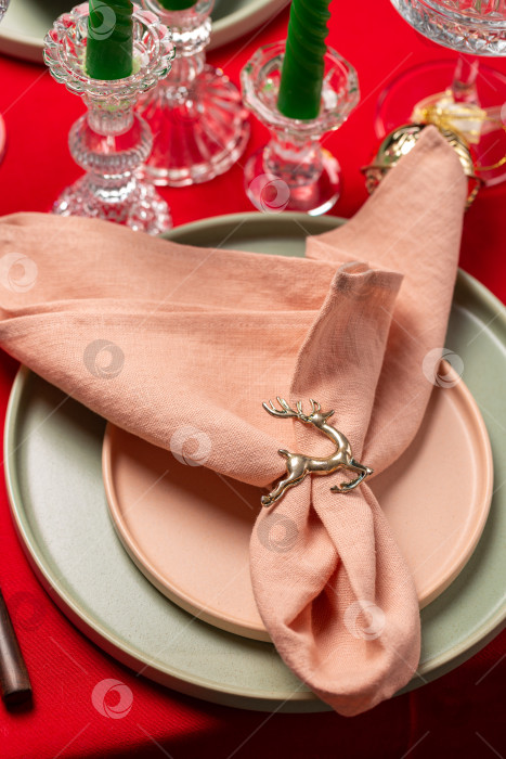 Скачать Рождественский сервиз для ужина, красная льняная скатерть, две тарелки, розовая льняная салфетка с кольцом с фигуркой оленя фотосток Ozero