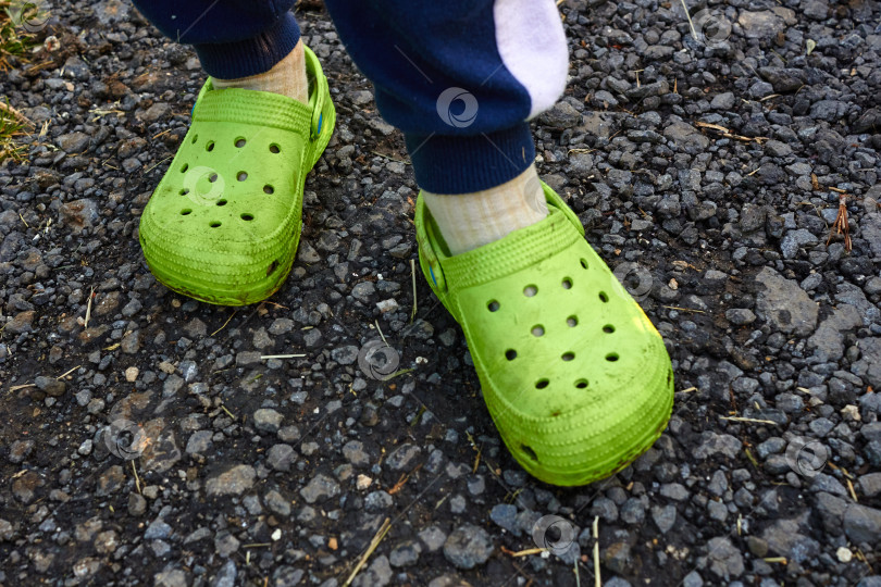 Скачать Фото детские ножки в саду, зеленые кроксы на фоне фотосток Ozero