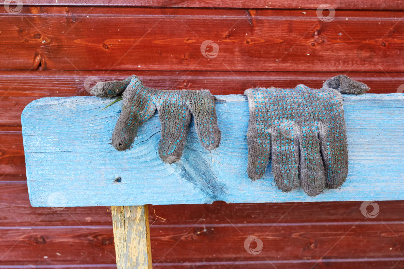 Скачать старые грязные садовые перчатки лежат на синей скамейке. фотосток Ozero