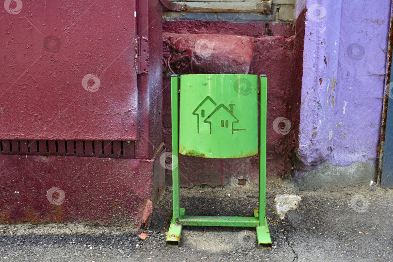 Скачать зеленое мусорное ведро на стене дома. фотосток Ozero