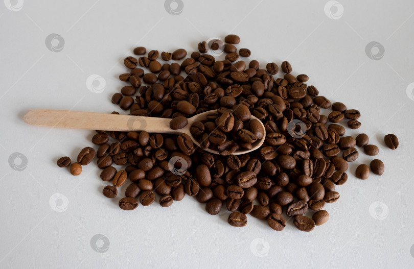 Скачать Ароматные кофейные зерна в деревянной ложке для приготовления вкусного кофе. Цельнообжаренные кофейные зерна для помола фотосток Ozero